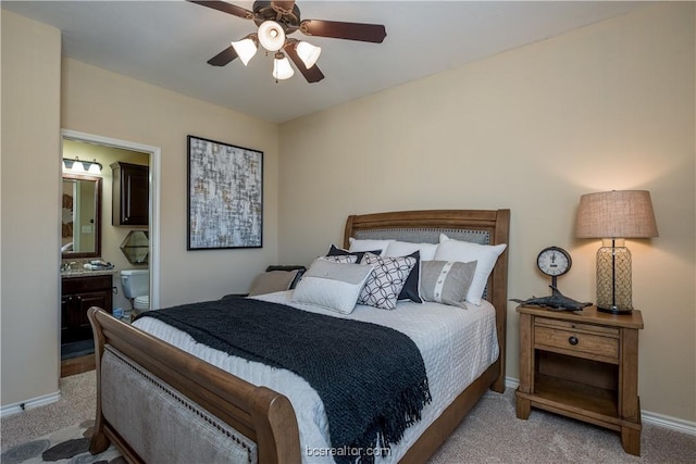 carpeted bedroom featuring ensuite bath and ceiling fan