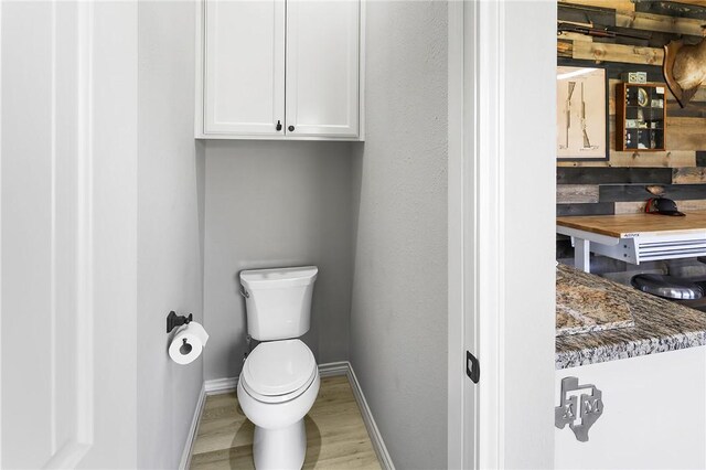 bathroom featuring toilet, baseboards, and wood finished floors