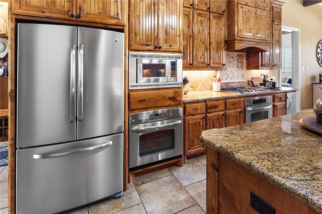 kitchen featuring brown cabinetry, appliances with stainless steel finishes, and decorative backsplash