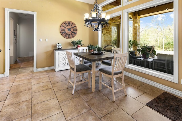 dining area with light tile patterned floors, baseboards, and a chandelier