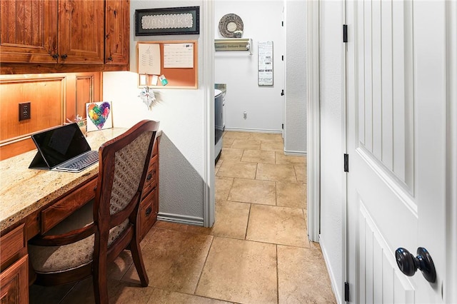 interior space featuring baseboards, light stone counters, washer / dryer, and brown cabinets