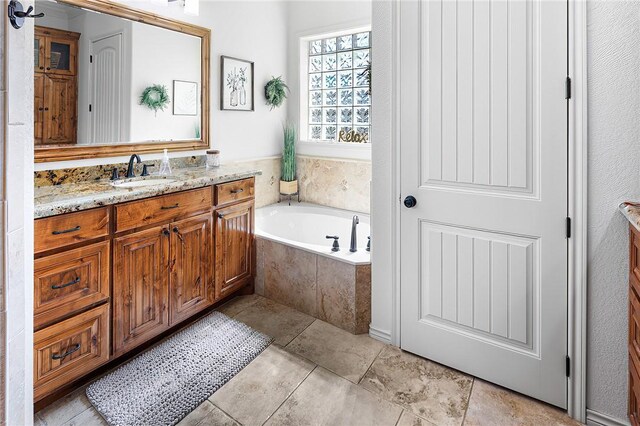 full bathroom featuring tile patterned flooring, vanity, and a bath