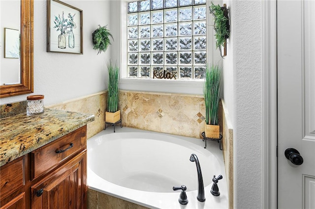 bathroom featuring vanity and a bath