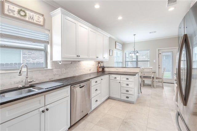 3089 Peterson Cir, Bryan, TX 77802 - kitchen featuring appliances with stainless steel finishes, a sink, crown molding, white cabinets, and tasteful backsplash