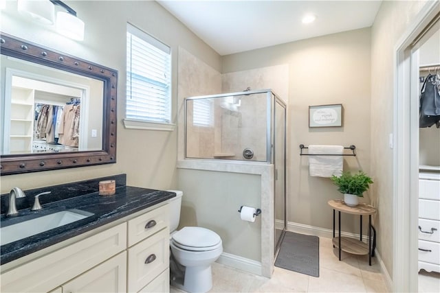 3089 Peterson Cir, Bryan, TX 77802 - full bathroom with a stall shower, a spacious closet, tile patterned floors, vanity, and toilet