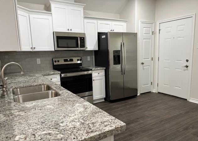 1207 N Houston Ave, Bryan, TX 77803 - kitchen with stainless steel appliances, a sink, white cabinetry, and dark wood-type flooring