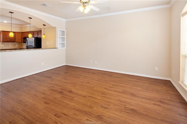 unfurnished living room with dark hardwood / wood-style floors, a wealth of natural light, and ornamental molding