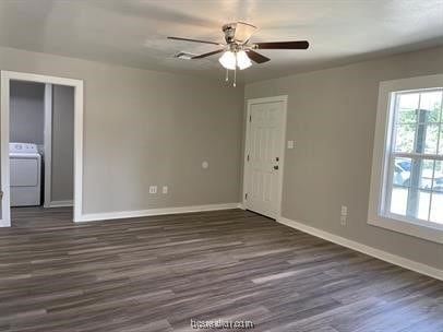 spare room with washer / dryer, dark hardwood / wood-style flooring, and ceiling fan