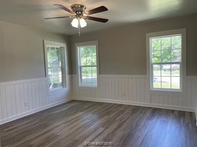 spare room with a wealth of natural light, dark hardwood / wood-style flooring, and ceiling fan