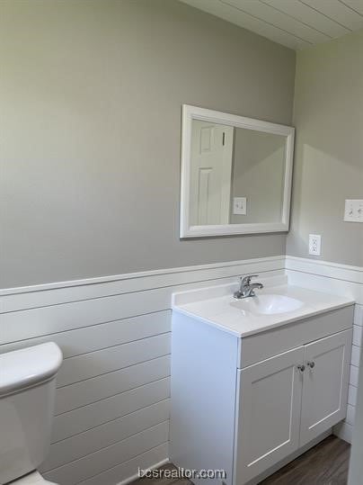 bathroom with vanity, wood-type flooring, and toilet