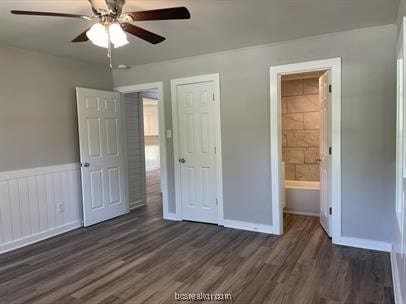 unfurnished bedroom with ceiling fan, dark wood-type flooring, and ensuite bath