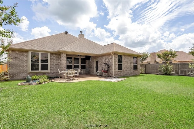 rear view of property featuring a patio and a lawn