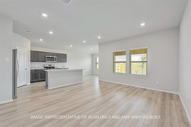 103 Comal Dr, Huntsville, TX 77340 - kitchen featuring appliances with stainless steel finishes, open floor plan, light wood-style floors, light countertops, and recessed lighting
