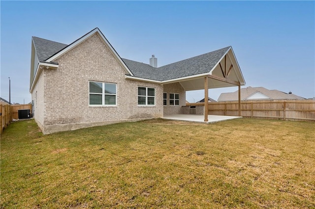 rear view of property with a yard, central AC unit, and a patio