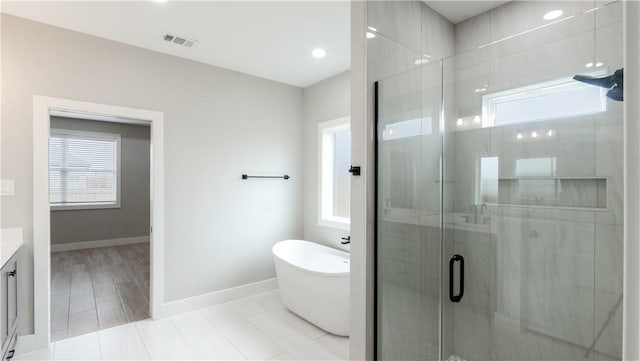 bathroom with vanity and separate shower and tub