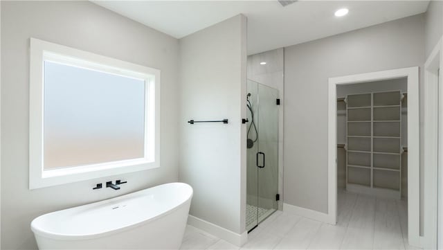 bathroom with a healthy amount of sunlight and separate shower and tub