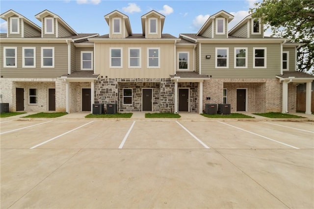 view of front of house featuring uncovered parking and central AC