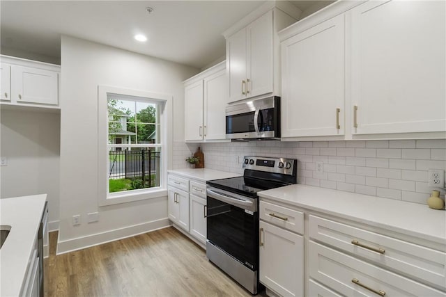 kitchen featuring white cabinetry, light countertops, light wood finished floors, and appliances with stainless steel finishes