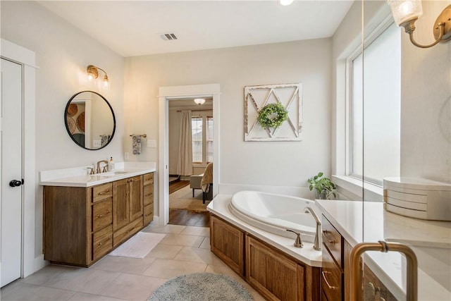 bathroom featuring tile patterned floors, a bathtub, plenty of natural light, and vanity