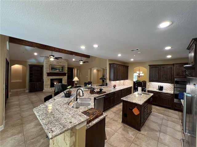 1142 Fletcher, Anderson, TX 77830 - kitchen with arched walkways, appliances with stainless steel finishes, a kitchen island with sink, ceiling fan, and open floor plan