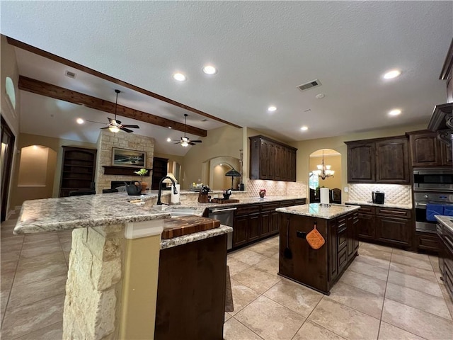 1142 Fletcher, Anderson, TX 77830 - kitchen with stainless steel appliances, arched walkways, a ceiling fan, backsplash, and dark brown cabinets