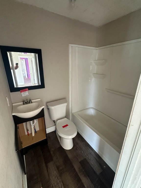 full bathroom featuring wood-type flooring, vanity, bathing tub / shower combination, and toilet