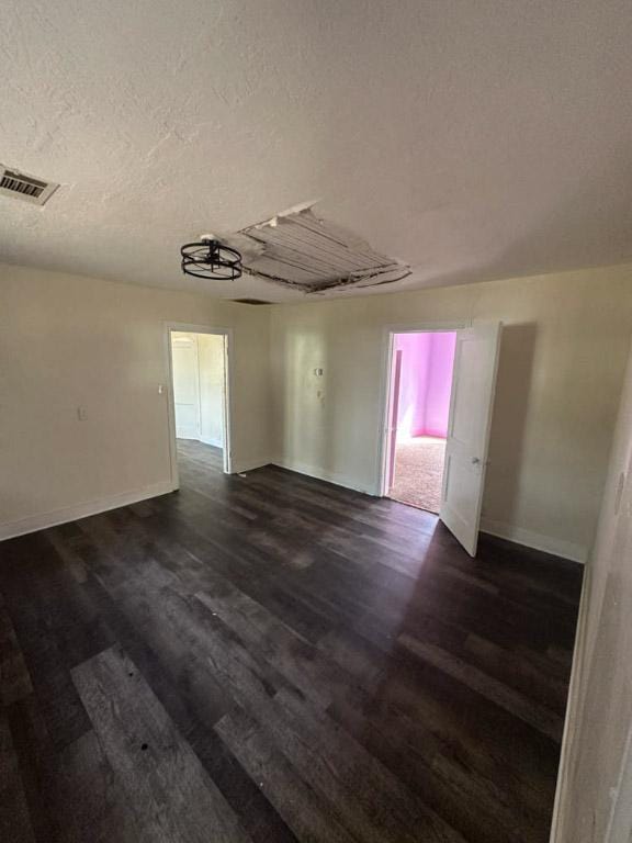 unfurnished room featuring a textured ceiling and dark wood-type flooring