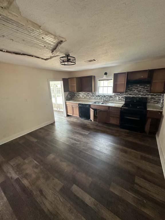 kitchen featuring backsplash, black appliances, sink, a textured ceiling, and dark hardwood / wood-style flooring