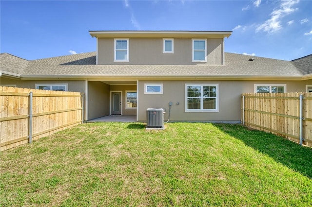 rear view of property featuring a lawn, central air condition unit, and a patio