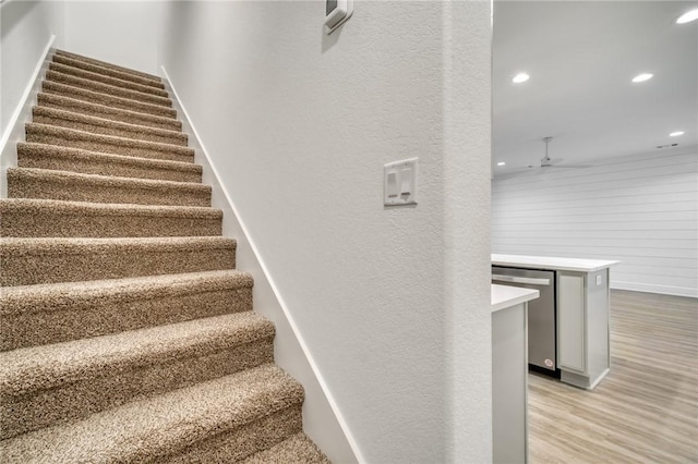 stairway featuring hardwood / wood-style flooring and ceiling fan