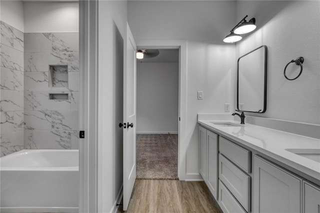 bathroom featuring hardwood / wood-style flooring, vanity, and a tub