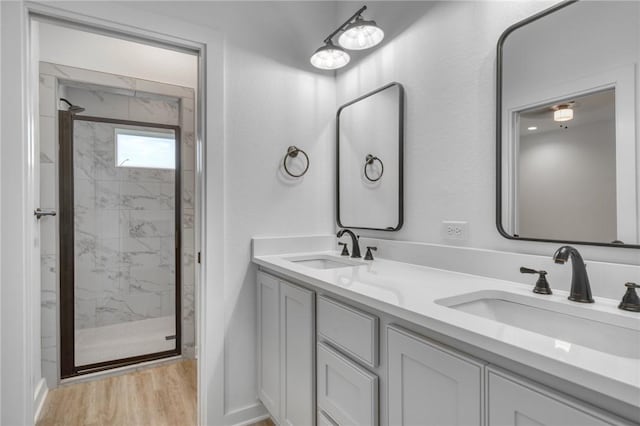 bathroom featuring walk in shower, vanity, and hardwood / wood-style flooring