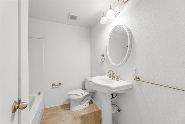 bathroom with toilet, a tub to relax in, and tile patterned floors