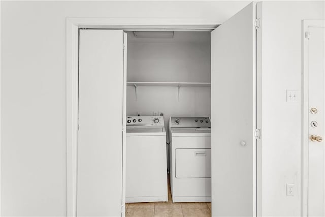 washroom featuring washer and clothes dryer and light tile patterned flooring