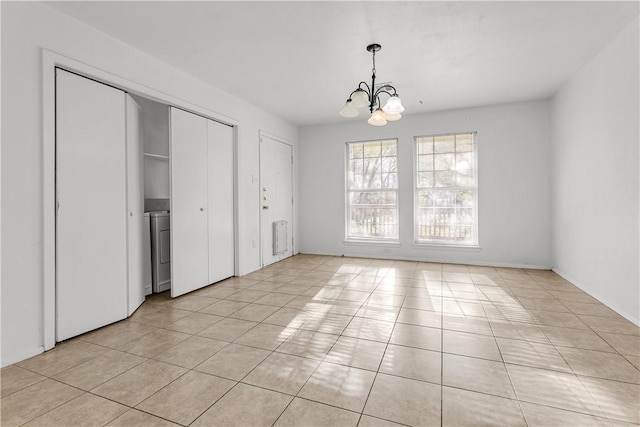 unfurnished dining area featuring an inviting chandelier and light tile patterned floors