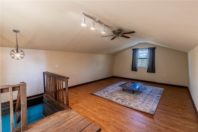 bonus room featuring lofted ceiling, wood finished floors, a ceiling fan, and baseboards