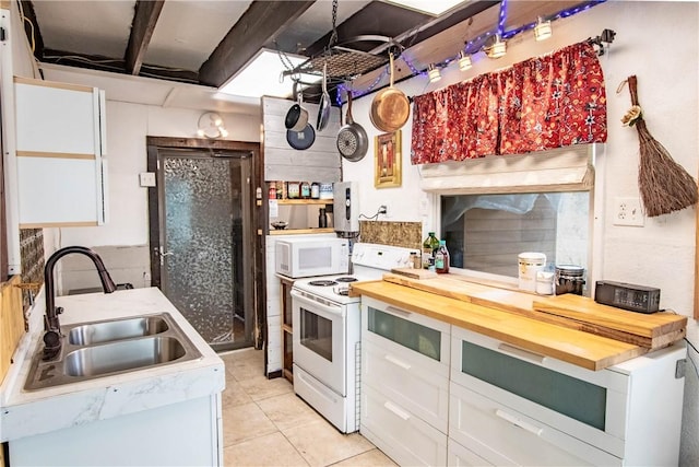 317 Beaver Lndg, Caldwell, TX 77836 - kitchen with a sink, butcher block countertops, white cabinetry, white appliances, and light tile patterned floors