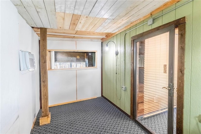 hallway featuring wood walls, wood ceiling, baseboards, and an AC wall unit