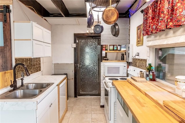 kitchen featuring white appliances, white cabinetry, wooden counters, and a sink