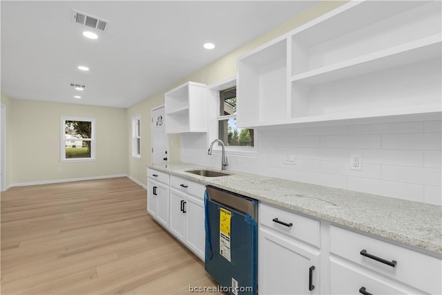 kitchen with light stone countertops, dishwasher, plenty of natural light, and light hardwood / wood-style flooring