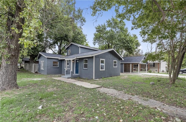 back of house with a carport and a lawn