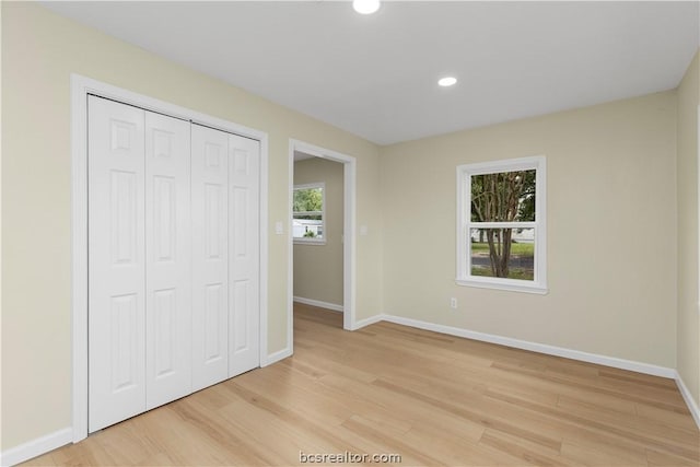 unfurnished bedroom featuring light hardwood / wood-style floors and a closet