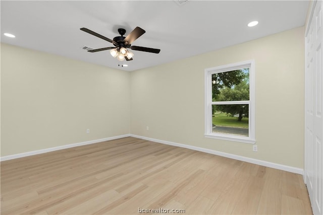 empty room with ceiling fan and light hardwood / wood-style flooring