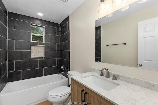 full bathroom with vanity, toilet, and tiled shower / bath