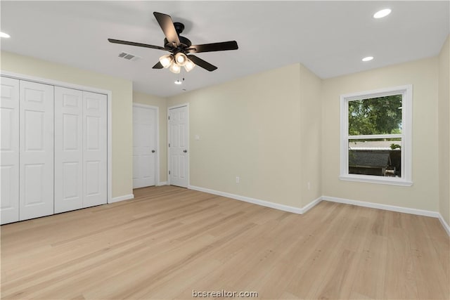 unfurnished bedroom with multiple closets, ceiling fan, and light hardwood / wood-style floors