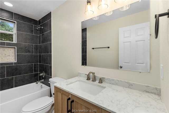 full bathroom featuring tiled shower / bath combo, toilet, and vanity