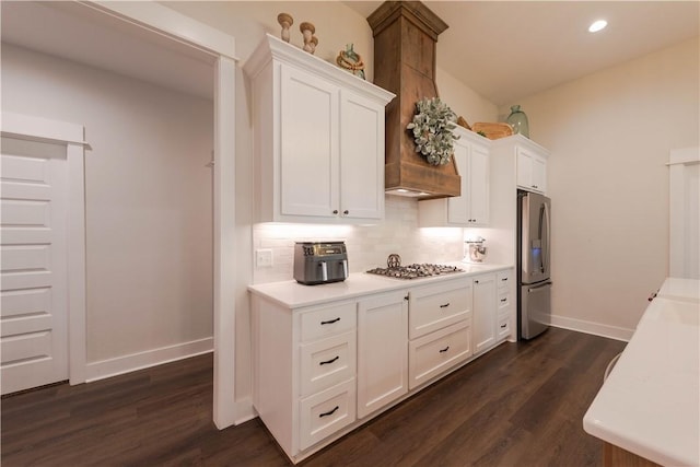 kitchen featuring dark hardwood / wood-style floors, white cabinetry, backsplash, and appliances with stainless steel finishes