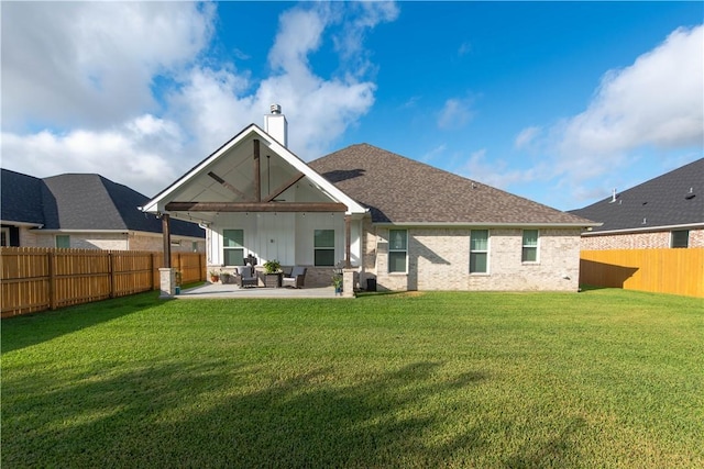 back of property featuring outdoor lounge area, a patio area, and a lawn