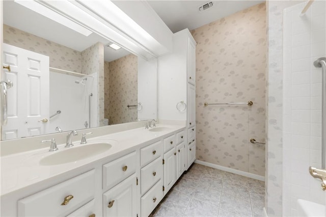 9300 Essex Grn, College Station, TX 77845 - full bath with tile patterned floors, a shower, double vanity, wallpapered walls, and baseboards