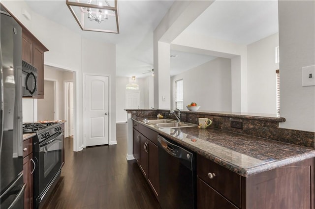 2031 Positano Loop, Bryan, TX 77808 - kitchen featuring black appliances, a sink, dark stone countertops, dark wood finished floors, and dark brown cabinetry